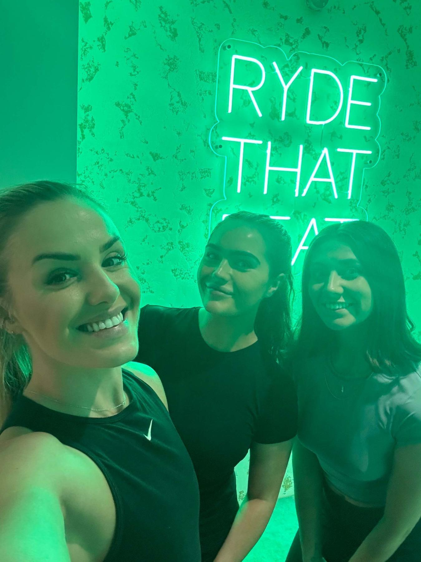 women smiling under neon sign
